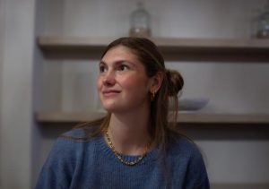 Eine junge blonde Frau schaut zur Seite und lächelt