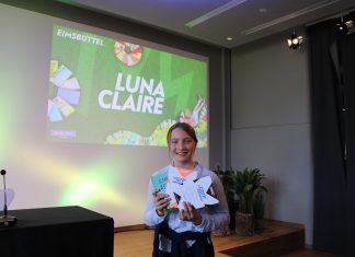 Die beste Vorleserin Hamburgs steht fest Ein Mädchen steht mit einer Urkunde vor einer Leinwand.