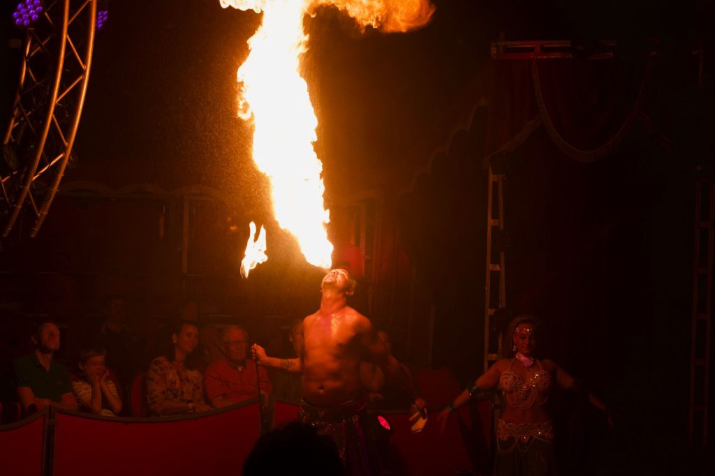 Feuerspucker spuckt große Flamme.