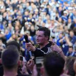 HSV feiert Aufstieg mit 120.000 Fans Auf dem Bild ist HSV-Trainer Merlin Polzin zu sehen, der inmitten der Fans steht und ihnen ein Mikrofon entgegenhält.