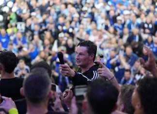 HSV feiert Aufstieg mit 120.000 Fans Auf dem Bild ist HSV-Trainer Merlin Polzin zu sehen, der inmitten der Fans steht und ihnen ein Mikrofon entgegenhält.