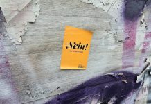 Die neue Staatsoper: Hamburgs Millionenfrage An einer mit Graffiti bemalten Wand ist ein gelber Sticker zu sehen. Auf diesem steht "Nein! zur Kühne-Oper". Der Sticker kommt vom AStA der Hafencity Universität.