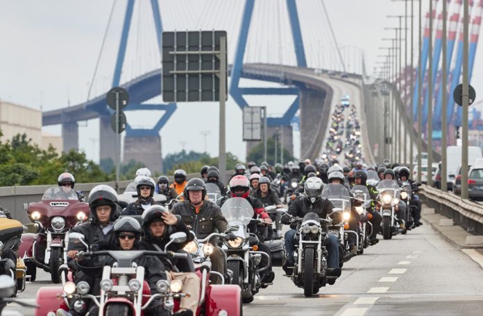 Viele Motorradfahrerende auf einer Straße auf einer Brücke auf dem Weg zu der Motorrad-Parade.