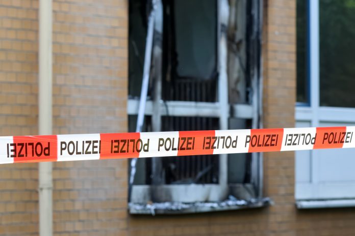 Absperrung der Polizei vor einem verbrannten Fenster des Marienkrankenhaus