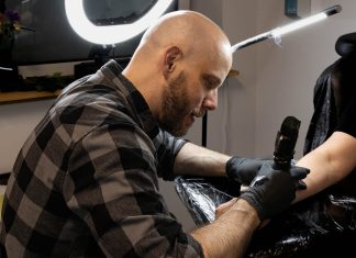 Tinte statt Hetze: Tattoo-Aktion gegen rechts Ein Mann tätowiert einen Arm.