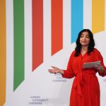 Zweite Hamburger Nachhaltigkeitskonferenz Reem Alabali-Radovan steht bei der Eröffnung der Hamburg Sustainability Conference vor einer bunt gestreiften Wand.
