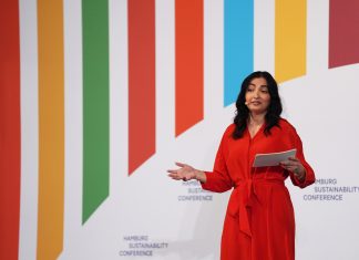 Zweite Hamburger Nachhaltigkeitskonferenz Reem Alabali-Radovan steht bei der Eröffnung der Hamburg Sustainability Conference vor einer bunt gestreiften Wand.