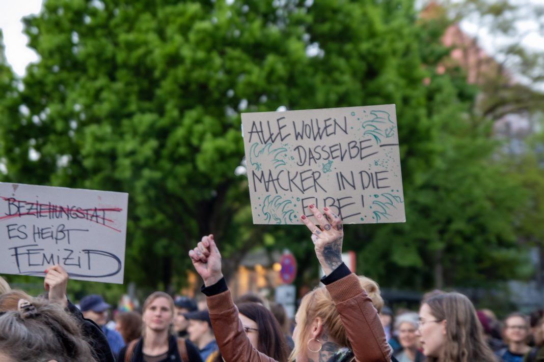 Demonstrierende bei Take back the Night halten Fäuste und Plakate in die Luft