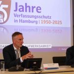 Nahost-Konflikt verstärkt Extremismus in Hamburg Zwei Männer sitzen an einem Tisch. Sie tragen schwarze Anzüge und stellen den Verfassungsschutzbericht vor.