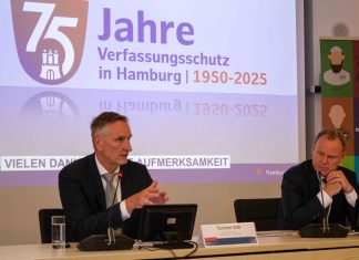 Nahost-Konflikt verstärkt Extremismus in Hamburg Zwei Männer sitzen an einem Tisch. Sie tragen schwarze Anzüge und stellen den Verfassungsschutzbericht vor.