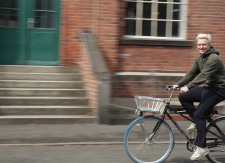 HAW Hamburg stellt erneut Team beim Stadtradeln Ein junger Mann auf dem Fahrrad. Im Hintergrund ist ein Steingebäude, Bewegungsunschärfe