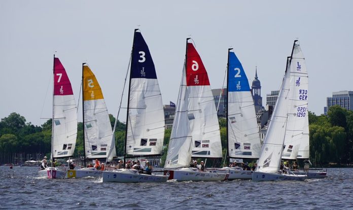 Sieben Segelboote mit bunten Segeln beim Start einer der Regatten des Helga Cups
