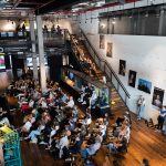 Social Design Week 2025 – Stadt gemeinsam denken Viele Menschen sitzen in einem Raum.