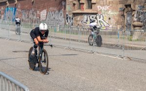 Drei Triathlet*innen fahren auf Rennrädern auf der asphaltierten Radstrecke des Ironman Hamburg.