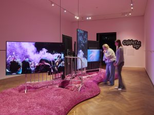 zwei Personen in einem Raum mit pinker Masse auf dem Boden
