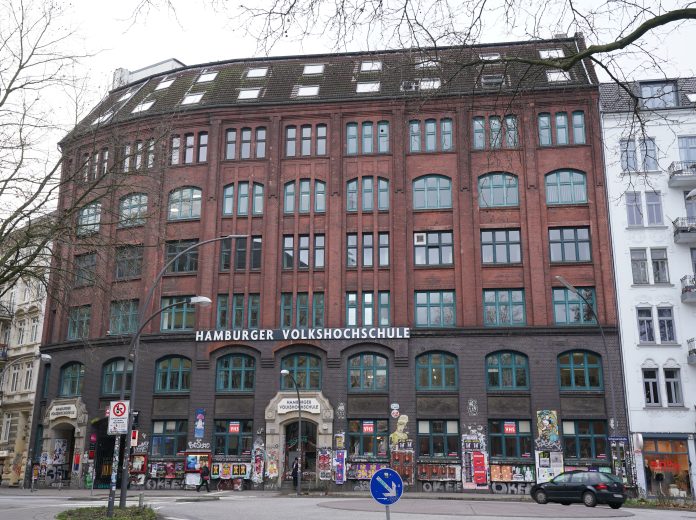 Ein Backsteingebäude an einer Straße mit dem goldenen Shcriftzug 