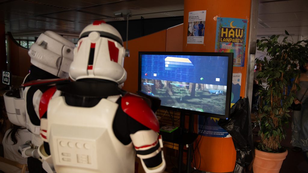 Zwei Personen in Stormtrooper-Kostümen spielen ein Videospiel