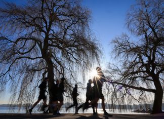 Am Wochenende wird es heiß Symbolbild für die Hitzewelle. Menschen laufen bei Sonnenschein um die Alster.