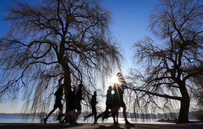 Symbolbild für die Hitzewelle. Menschen laufen bei Sonnenschein um die Alster.