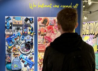 Ausstellung widmet sich respektvollem Verhalten Eine Person, in der Austellung über Respekt, von hinten steht vor einer Wand mit Postern.