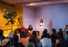 Lesereihe: Wurzeln schlagen als Widerstand Kübra Gümüsay und Alena Jabarine sitzen auf der Couch, während Jessica die Lesung vor dem Publikum eröffnet.