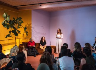 Lesereihe: Wurzeln schlagen als Widerstand Kübra Gümüsay und Alena Jabarine sitzen auf der Couch, während Jessica die Lesung vor dem Publikum eröffnet.