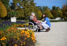 SeRAH: KI-Kurs soll ethische Kompetenz von Pflegekräften stärken Eine ältere Frau in einem Rollstuhl spricht mit einer Pflegekraft.