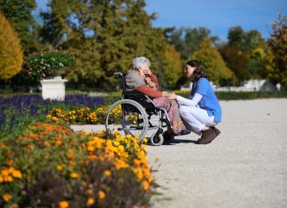 SeRAH: KI-Kurs soll ethische Kompetenz von Pflegekräften stärken Eine ältere Frau in einem Rollstuhl spricht mit einer Pflegekraft.
