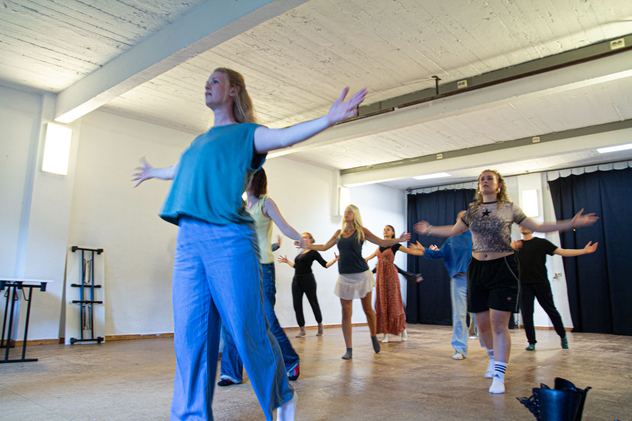 Die Schauspielschüler*innen heben die Arme waagerecht zum Körper und strecken sie zur Seite.