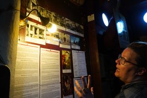 Carolin Uhde vor einer Wand welche die Geschichte des Hafenbasars erzählt. (Foto: Hendrik Heiermann)