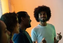 „Mehrstimmm.Ich“ – Ein Gesangsworkshop, der Schwarze Stimmen hörbar macht FAYIM schaut stolz auf drei Workshop-Teilnehmer*innen und lächelt dabei. Die Teilnehmer*innen singen.