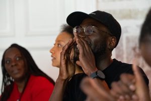 Eine Workshop Teilnehmer hält seine Hände an den Mund und Ruft.