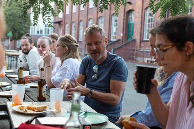 Mehrere Personen sitzen an einem Tisch und unterhalten sich.