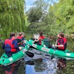 Green-Kayaks: Gratis-Paddeln und Umwelt schützen Zwei Green-Kayaks auf dem Wasser mit müllsammelnden Menschen.