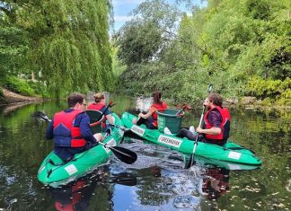 Green-Kayaks: Gratis-Paddeln und Umwelt schützen Zwei Green-Kayaks auf dem Wasser mit müllsammelnden Menschen.