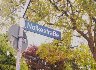 Zwischen sozialem Mehrwert und Belastungsprobe Ein Straßenschild, auf dem Notkestraße steht. Im Hintergrund sind Bäume.