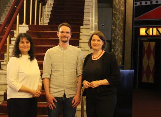 Kultur auf der Leinwand Ein Mann und zwei Frauen stehen vor einer Treppe.