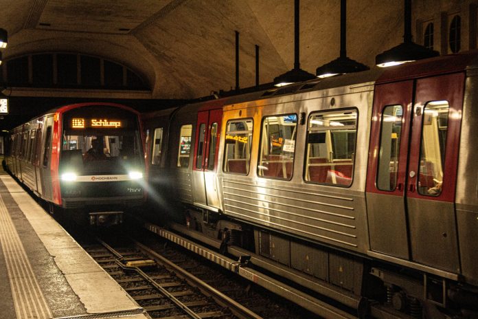 Zwei U-Bahnen fahren in der Haltestelle Mundsburg.