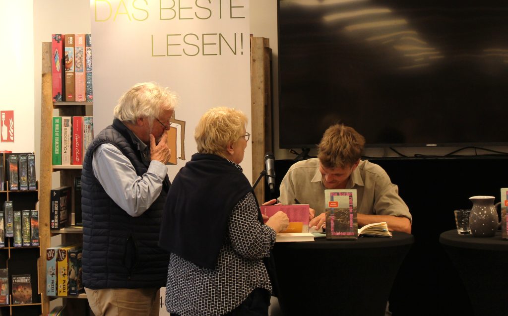 Ein Ehepaar lässt sich ihr Buch beim Autor signieren