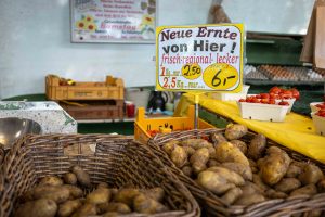 Nahaufnahme von Kartoffeln. Das Preisschild zeigt sechs Euro.