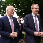 Norden berät über Sicherheit und Olympia-Bewerbung Zwei Politiker in Anzügen treffen zu einer Sitzung ein.