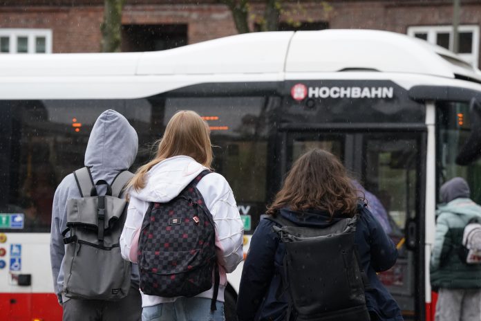 Schülerinnen und Schüler steigen in einen Bus der Hamburger Hochbahn.