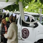 Ein Van für den guten Streit – unterwegs mit dem Streitmobil Katja Kaiser steht vor ihrem Streitmobil und unterhält sich mit einer anderen Person.