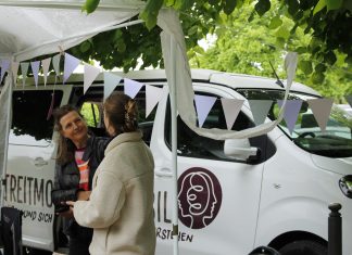 Ein Van für den guten Streit – unterwegs mit dem Streitmobil Katja Kaiser steht vor ihrem Streitmobil und unterhält sich mit einer anderen Person.