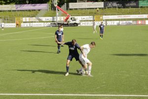 Zwei Spieler im direkten Zweikampf um den Ball.