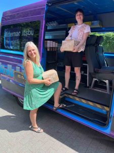Sonja Norgall (links) und Corinna Schnaus (rechts) tragen Tetrapacks mit Wasser in den Mitternachtsbus.