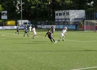 Vom Gaming-Stuhl auf den grünen Rasen Zehn Fußballer in einer Spielszene. Einer schlägt eine Flanke, die anderen stehen herum.