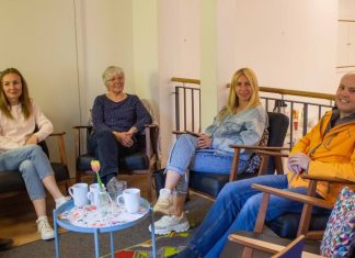 Das Sprachcafé Eimsbüttel – Zwischen Grammatik und Gesprächen Vier Personen sitzen in einem Stuhlreis und lächeln.