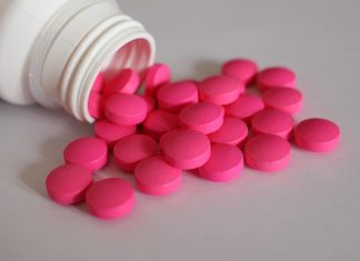 Drug-Checking: Senat veröffentlicht Modellvorhaben Eine weiße Pillendose aus der pinke Tabletten fallen als Symbolbild fürs Drug-Checking.