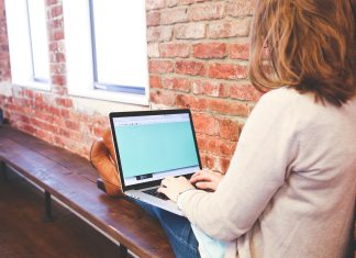 Studieren in Hamburg: Häufig nur zulassungsbeschränkt Eine Frau sitzt auf einer Bank und tippt auf einem Laptop.